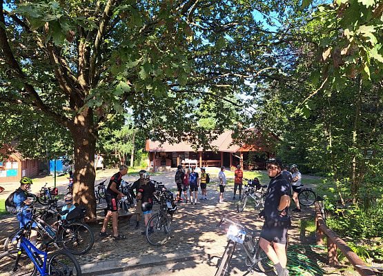 Uczestnicy rajdu stojący przy dębie na podworku Zielonej Szkoły.