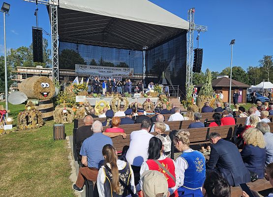 Scena z prowadzącymi uroczystości dożynkowe i gośćmi.